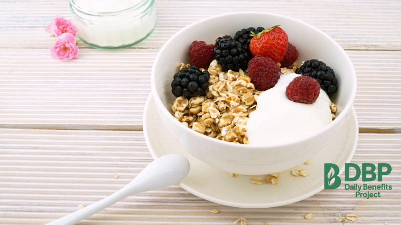 Bowl of Greek yogurt topped with fresh berries and granola on a wooden table